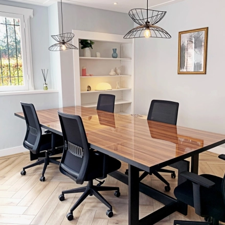 Bright office space rental in Amsterdam Old South with a wooden table and four chairs, under modern pendant lights. Ideal environment for meetings or collaborative work. Available for rent at Emmalaan 7-9.