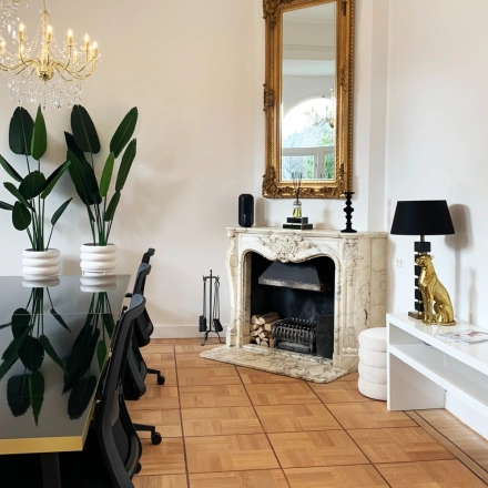Elegant office space available for rent in Amsterdam Old South, featuring a stylish conference table, decorative fireplace, and chic furnishings at Emmalaan 7-9.