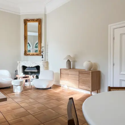 Bright office space with modern furniture and a fireplace, located at Emmalaan 7-9, ideal for office space rental in Amsterdam Old South.