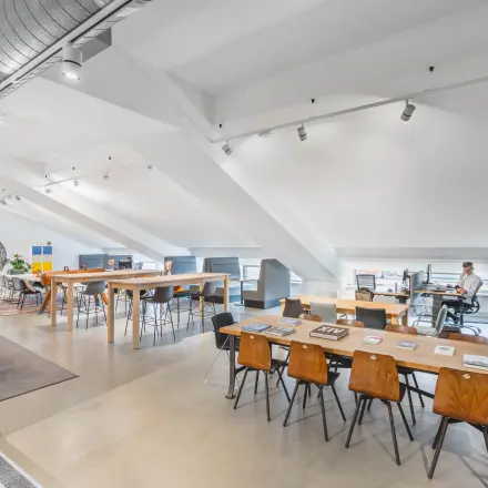 Bright office space at Olympisch Stadion 24-28, Amsterdam Old South, featuring modern workstations with people working. Ideal for office space rental.
