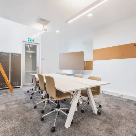 Furnished office space for rent at Olympisch Stadion 24-28, Amsterdam Old South, featuring a modern meeting area with conference table and chairs.