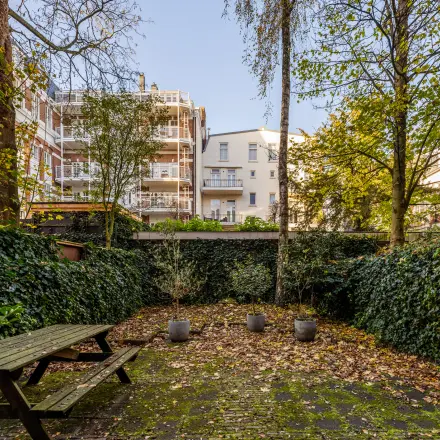 Exterior view of a courtyard surrounded by greenery at PC Hooftstraat 150, ideal for rent office space in Amsterdam Old South.