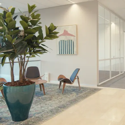 Spacious office entrance at David Ricardostraat 1 in Amsterdam Riekerpolder, featuring modern furnishings and vibrant decor. Ideal office space rental with comfortable seating area.