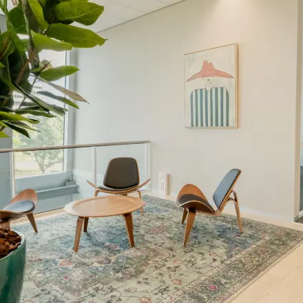 Bright office space with modern furnishings, featuring a seating area with chairs and a table, located at David Ricardostraat 1 in Amsterdam Riekerpolder. Ideal for office space rental opportunities.