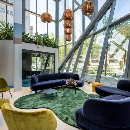 Bright office lounge area at David Ricardostraat 1 in Amsterdam Riekerpolder, featuring modern seating and large windows, ideal for office space rental.
