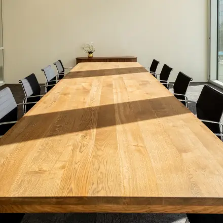 Spacious conference room with a long wooden table and modern chairs, ideal for office space rental in Amsterdam Riekerpolder.