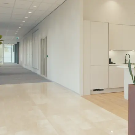 Bright and modern office to rent in Amsterdam Riekerpolder with stylish plants and a tidy kitchenette. Ideal for office space rental needs.