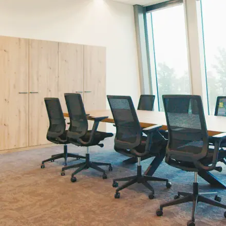 Modern workspace available for rent at David Ricardostraat 1, Amsterdam Riekerpolder, featuring a long table and ergonomic chairs, suitable for meetings and team collaborations.