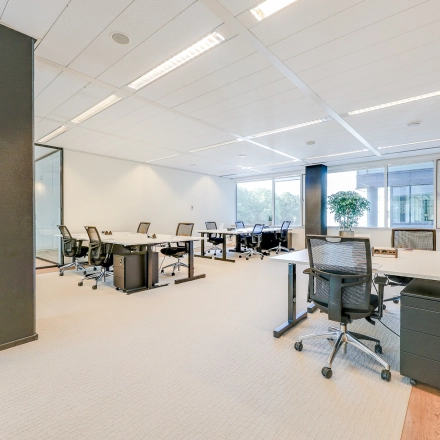 Bright office space with modern furniture and large windows at Thomas R. Malthusstraat 1-3, ideal for office space rental in Amsterdam Riekerpolder.