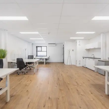 Modern office space at Arlandaweg 92, Amsterdam Sloterdijk, featuring wooden flooring, white walls, and a kitchenette, ideal for businesses seeking office space rental.