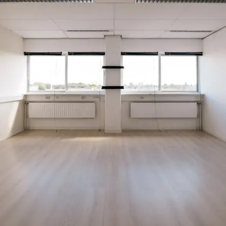Spacious unfurnished office space with large windows, located at Kabelweg 24, Amsterdam Sloterdijk, ideal for office space rental.