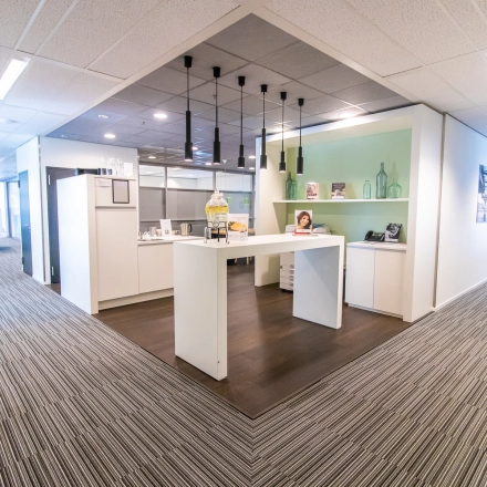 A modern office space at Radarweg 29, Amsterdam Sloterdijk, featuring a furnished area with a central high table and decorative shelves, ideal for office space rental.