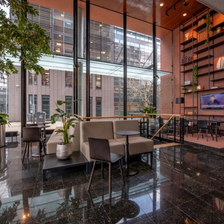 Modern office space for rent at Teleportboulevard 110, Amsterdam Sloterdijk, featuring a stylish furnished interior with seating areas and large windows.