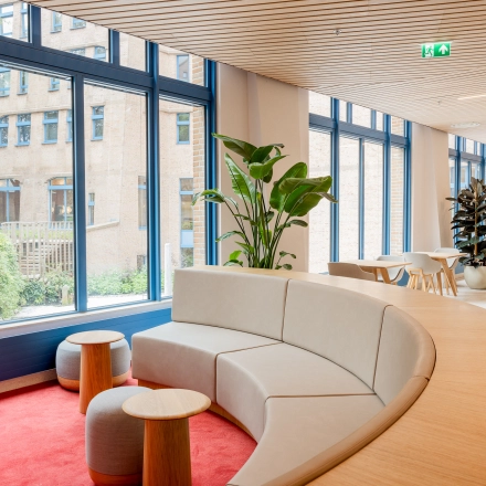 Spacious, modern office lounge with stylish seating and large windows at Bijlmerplein 888, Amsterdam South East, ideal for office space rental.