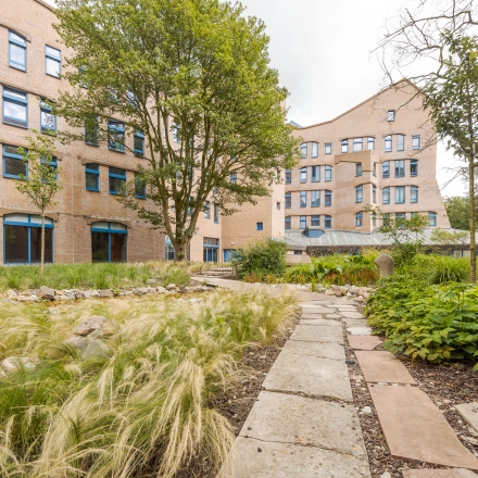 Exterior view of an office building with a garden at Bijlmerplein 888, Amsterdam South East, showcasing the opportunity for office space rental.