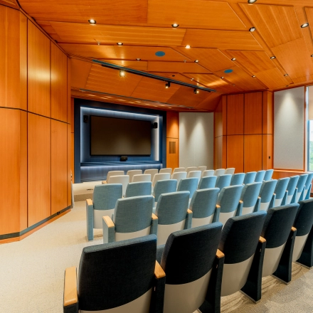 Seminar room at Bijlmerplein 888 in Amsterdam South East, featuring rows of cushioned chairs and a large presentation screen, ideal for office space rental.