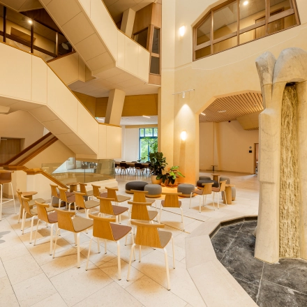 Bright office interior at Bijlmerplein 888, Amsterdam South East, featuring modern seating and a unique stone sculpture, ideal for office space rental or an office to rent.