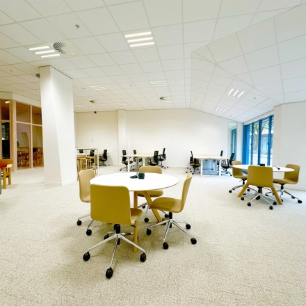 Modern office space for rent at Bijlmerplein 888, Amsterdam South East, featuring spacious workspaces with chairs, tables, and large windows offering natural light.