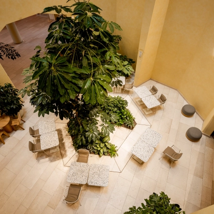 Bright office space rental at Bijlmerplein 888, Amsterdam South East, featuring modern seating and lush greenery.