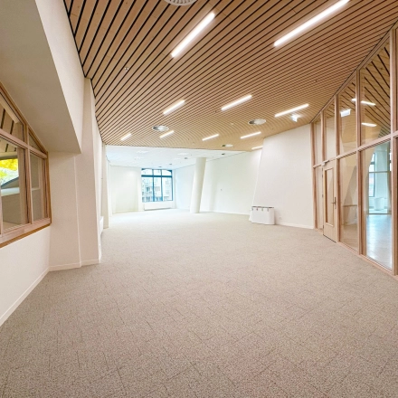 Spacious and modern office space at Bijlmerplein 888 in Amsterdam South East, featuring large windows and wooden ceiling accents, ideal for rent office space.