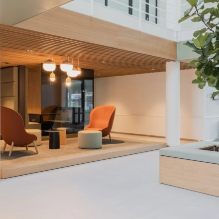 Spacious and modern office lounge in Amsterdam South East with stylish seating and natural lighting, ideal for office space rental.