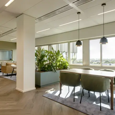 Bright office space with a mix of workstations and a seating area, located at Herikerbergweg 288, Amsterdam South East, ideal for office space rental.