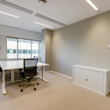 Modern office space for rent at Herikerbergweg 290 in Amsterdam South East, featuring a light-filled room with two workstations and ergonomic chairs.