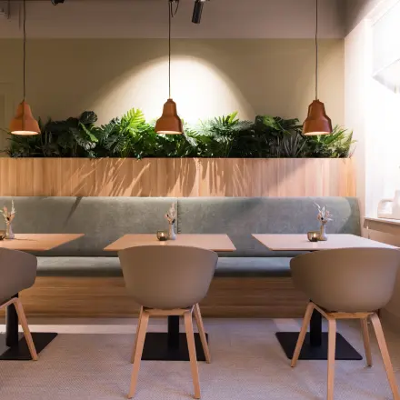 Modern office space at Hullenbergweg 109-135 in Amsterdam South East, featuring a stylish, furnished lounge area with plants and seating, available for rent.