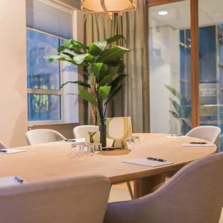 Light-filled conference room at Hullenbergweg 109-135, Amsterdam South East, featuring a modern wooden table with chairs, suitable for office space rental.