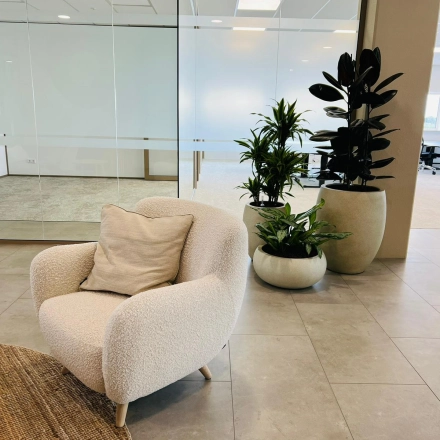 Modern office space in Amsterdam South East featuring cozy seating, plants, and glass-walled rooms, perfect for office space rental.