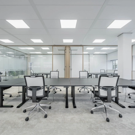 Spacious office interior in Amsterdam South East with modern furnishings and multiple desks, ideal for office space rental.
