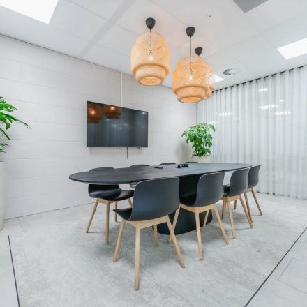 Modern conference room for office space rental at Laarderhoogtweg 7-19 in Amsterdam South East, featuring a large table, stylish chairs, and contemporary lighting.