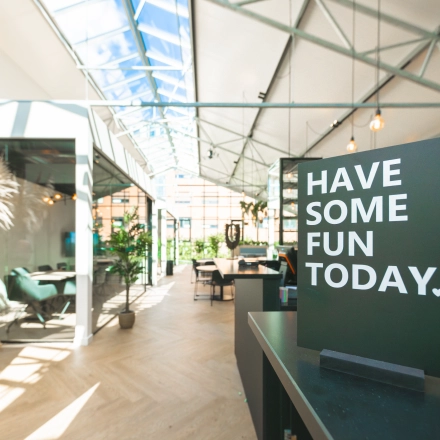Bright, airy office space rental with glass roof, greenery, and modern furnishings at Luttenbergweg 8. Ideal office to rent in Amsterdam South East for productive work.