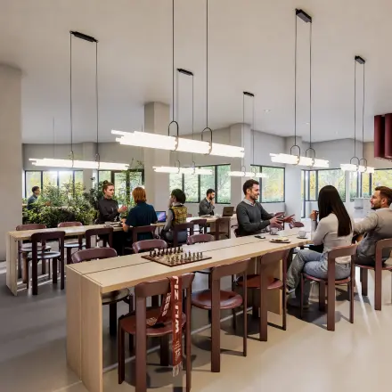 Spacious and modern workspace at Luttenbergweg 8, Amsterdam South East. People are engaged in business discussions around large wooden tables in a well-lit, furnished environment, ideal for office space rental.