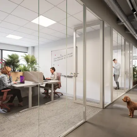 Office space for rent at Luttenbergweg 8, Amsterdam South East, featuring a modern workspace with glass partitions and natural light. Professionals engaging in meetings and discussions.