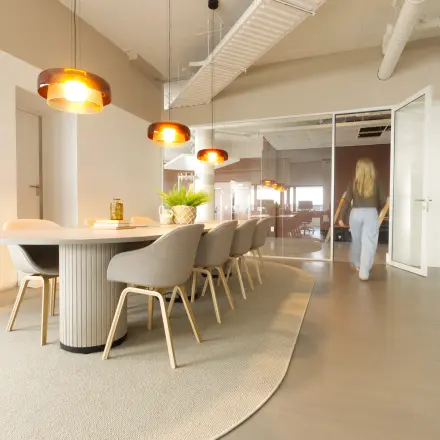 Modern office space at Luttenbergweg 8, Amsterdam South East with stylish furnishings and a meeting table, ideal for office space rental.