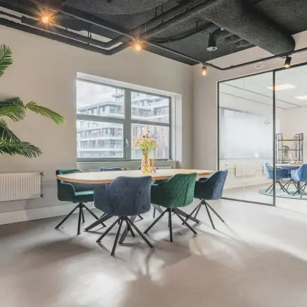 Bright office space with modern furnishings and a large conference table, located at Paasheuvelweg 20, Amsterdam South East, ideal for office space rental.