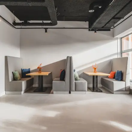 Modern office space rental at Paasheuvelweg 20 in Amsterdam South East, featuring cozy booth seating with cushions and a bright, inviting atmosphere.