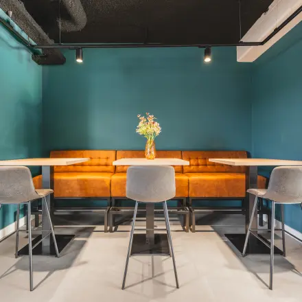Cozy office space at Paasheuvelweg 20, Amsterdam South East, featuring a comfortable seating area with tables and chairs in a modern design, ideal for rent office space.
