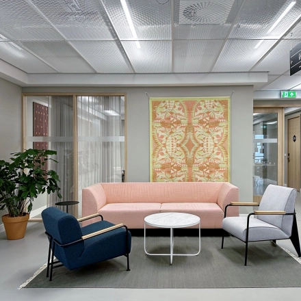 Modern office space for rent at Haarlemmerweg 331, Amsterdam West, featuring stylish furniture and vibrant wall art, ideal for collaborative meetings.