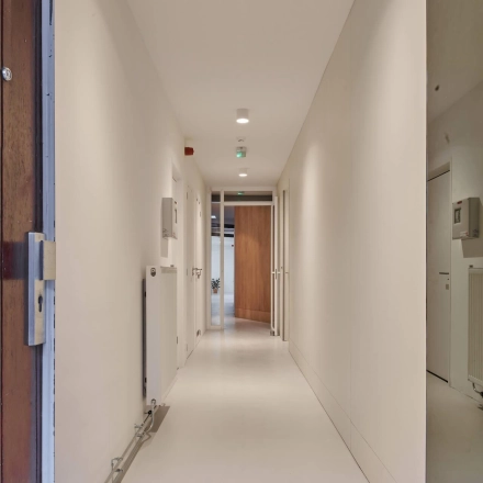 Bright, well-lit corridor in an office building located at Hondiusstraat 7H, Amsterdam West, ideal for seamless office space rental with modern design elements.