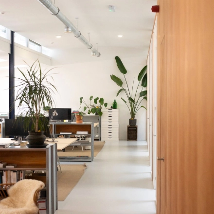 Modern office space at Hondiusstraat 7H, Amsterdam West, featuring open workstations with sleek furnishings and ample natural light, ideal for office space rental.