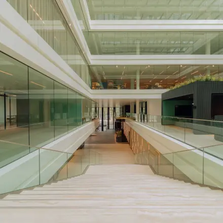 Spacious interior with modern glass architecture at Kon. Wilhelminaplein 4, Amsterdam West, perfect for rent office space. Bright and open with sleek design, offering potential for versatile office space rental.