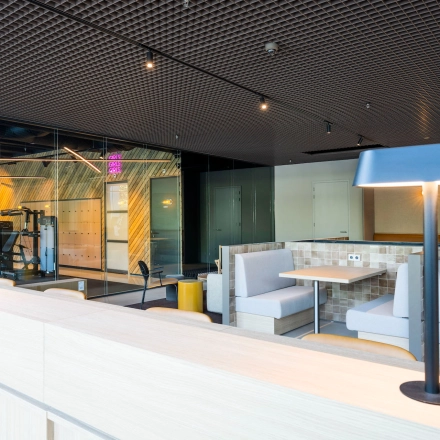 Modern office space for rent at Nachtwachtlaan 20, Amsterdam West, featuring stylish booth seating and a gym area.