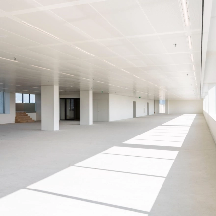 Bright, unfurnished open floor plan office to rent at Nachtwachtlaan 20, Amsterdam West, featuring large windows and ample natural light.