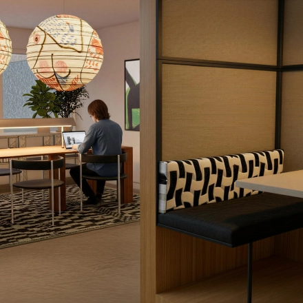 A furnished office space with a person using a laptop at Barbara Strozzilaan 101 101, Amsterdam Zuidas. Ideal for office space rental, featuring modern seating and decorative lighting.