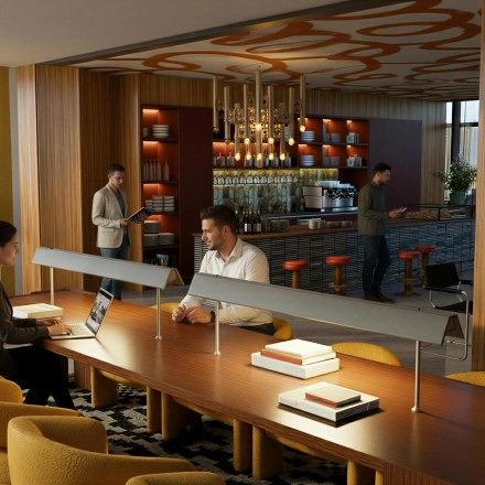 Modern workspace at Barbara Strozzilaan 101 101, Amsterdam Zuidas, featuring a cozy meeting area and a stylish bar. People are engaged in discussions and work. Ideal office space rental opportunity.