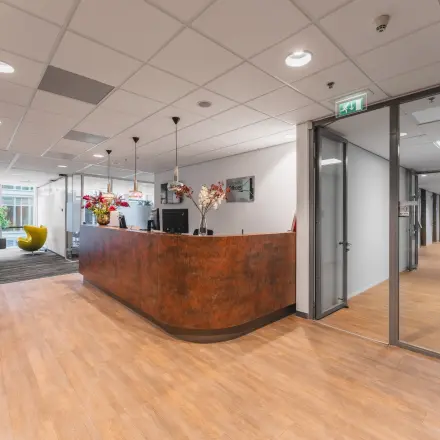 Spacious office reception at Claude Debussylaan 10, features modern furniture and large windows, ideal for office space rental in Amsterdam Zuidas.