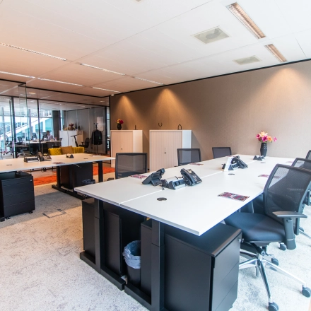 Modern furnished office space at Claude Debussylaan 7-29 in Amsterdam Zuidas, featuring sleek desks and chairs ready for office space rental.