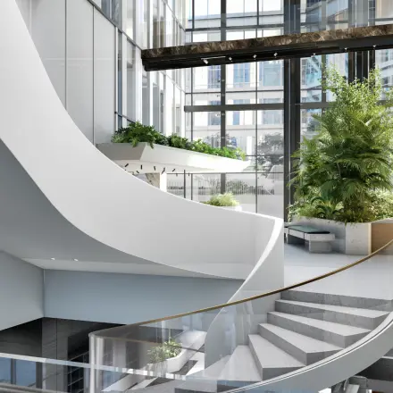 Bright office interior at Claude Debussylaan 80-134, Amsterdam Zuidas, featuring modern architecture, open stairway, and lush plants, perfect for office space rental with a refreshing ambiance.